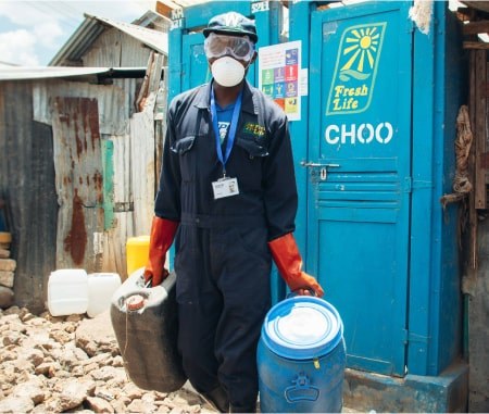A Fresh Life sanitation worker beside a Fresh Life toilet